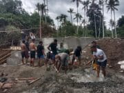 Penuh Semangat, TNI dan Warga Gotong Royong Cor Dudukan Jembatan Garuda